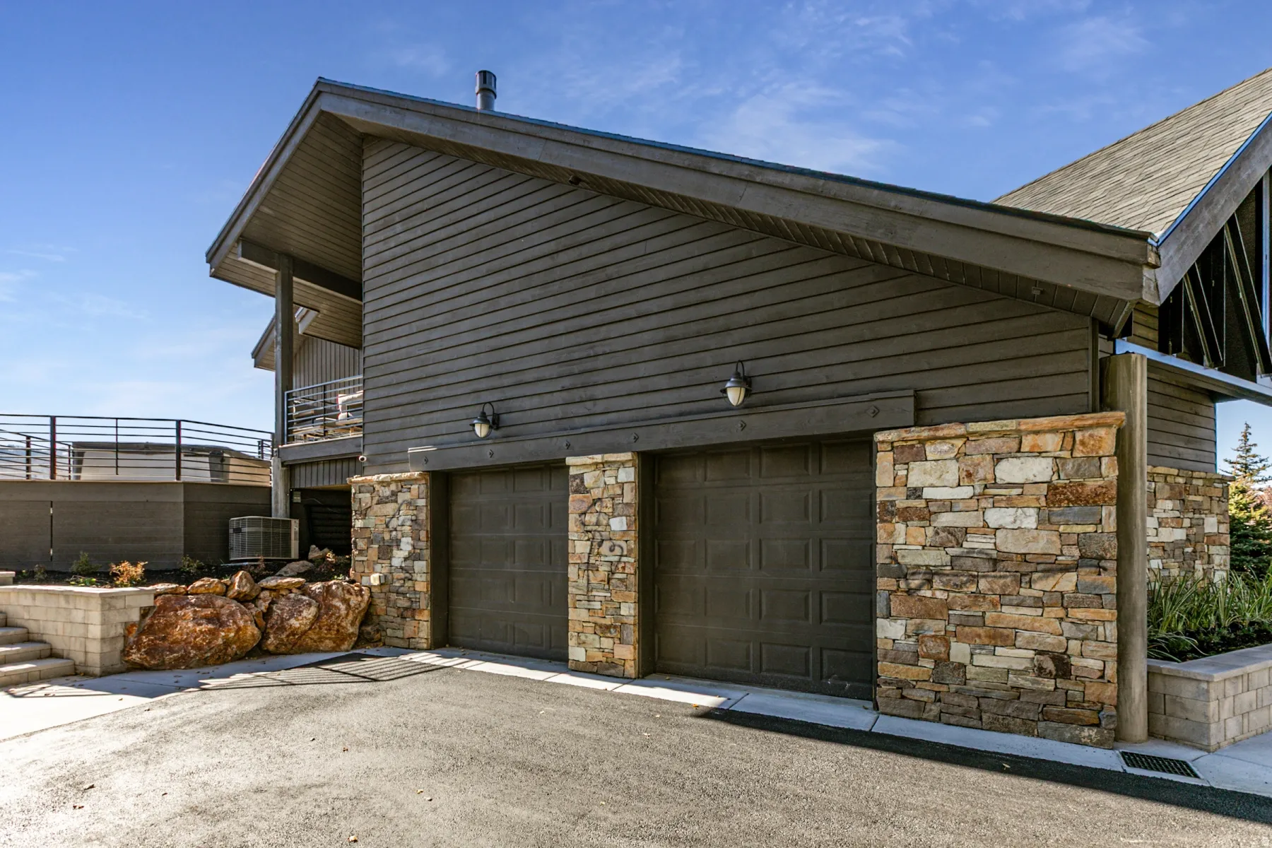 View of property exterior featuring stone siding and driveway