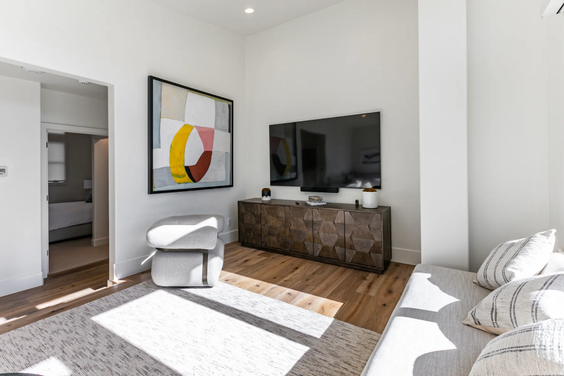 Living area featuring wood finished floors, a wall unit AC, and recessed lighting