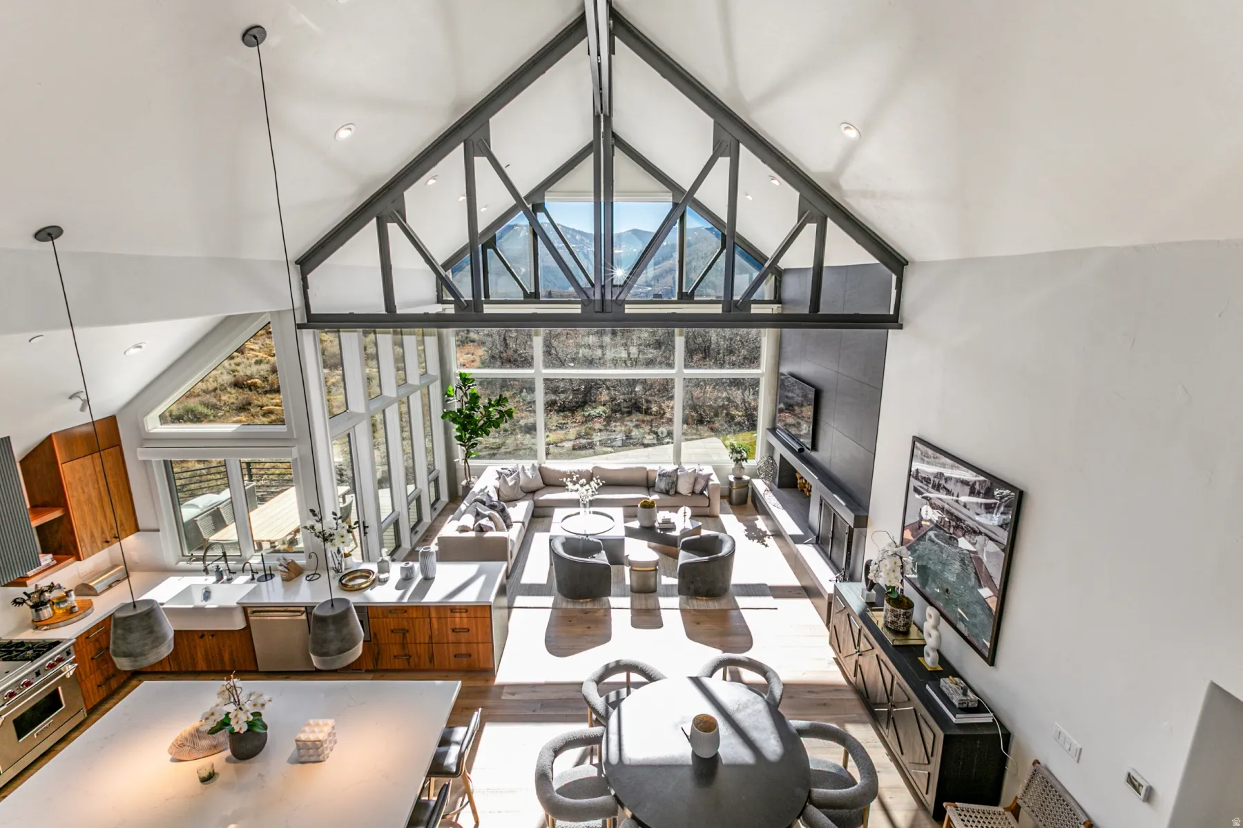 Dining space with high vaulted ceiling, floor to ceiling windows, and wood finished floors