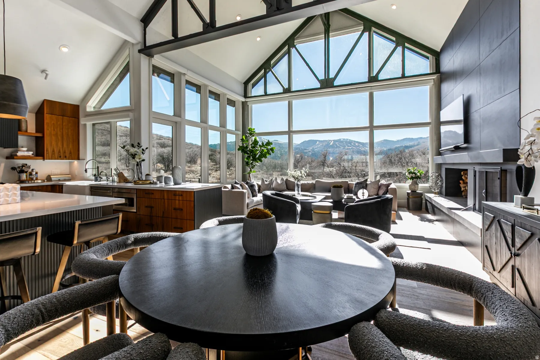 Dining space with high vaulted ceiling, a large fireplace, plenty of natural light, and recessed lighting