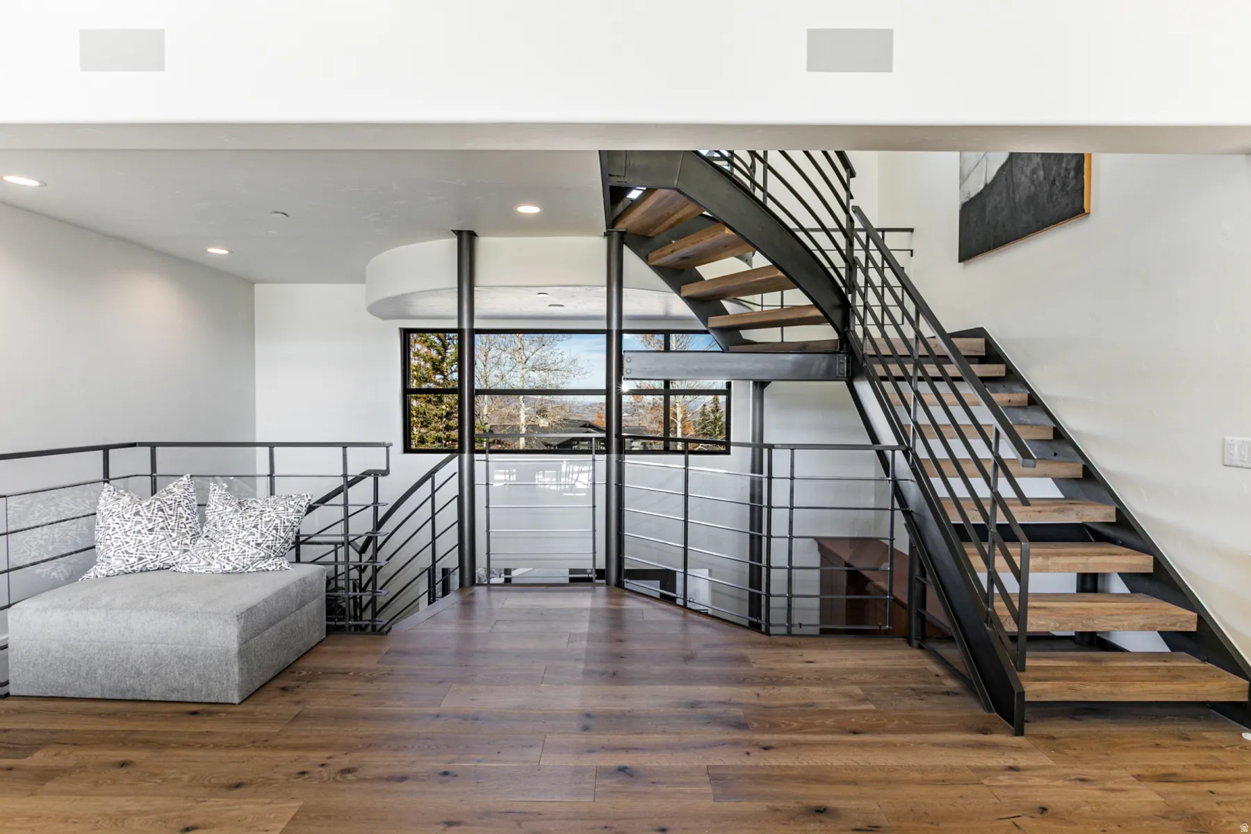 Stairs with hardwood / wood-style floors and recessed lighting