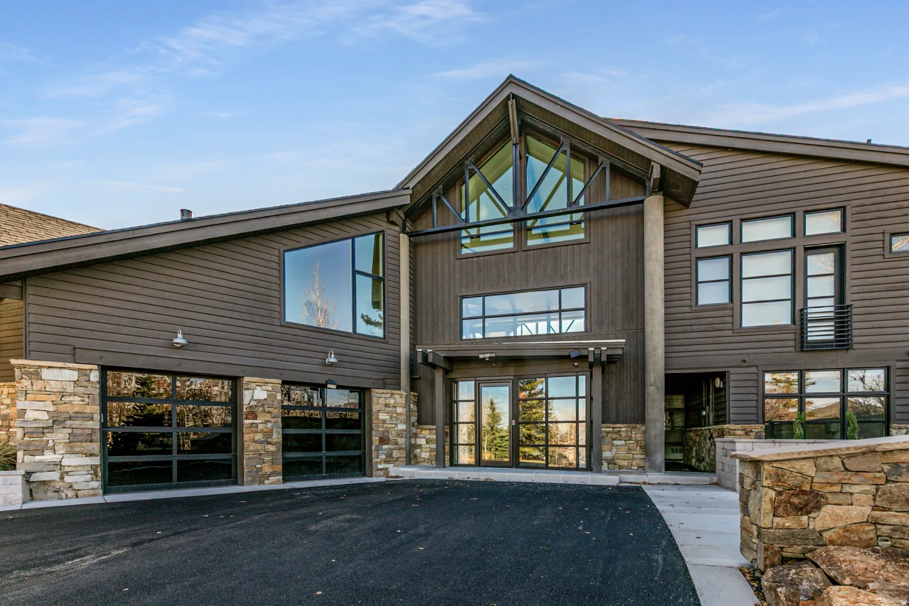 View of property with asphalt driveway and a garage