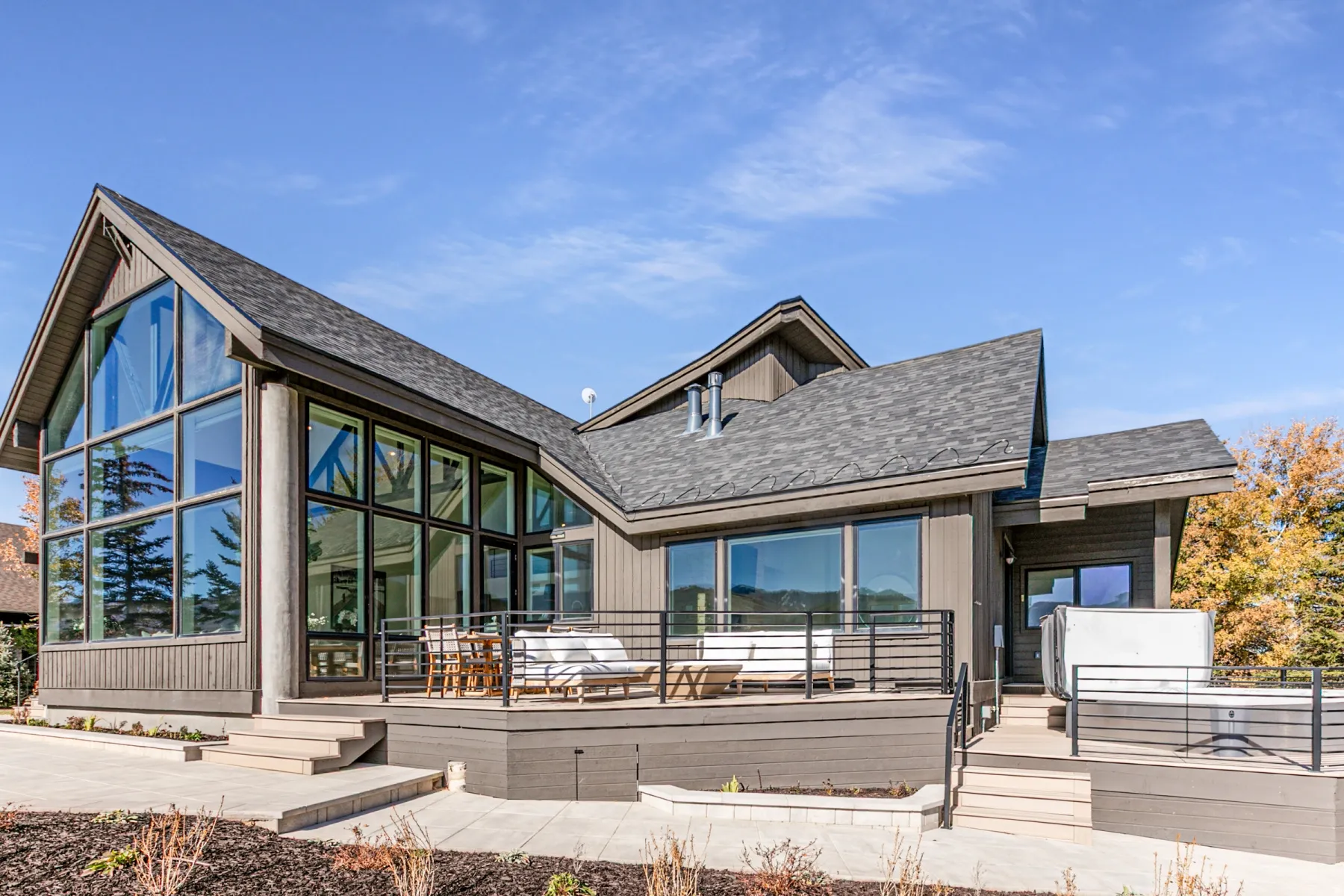 Back of property featuring a shingled roof and a wooden deck