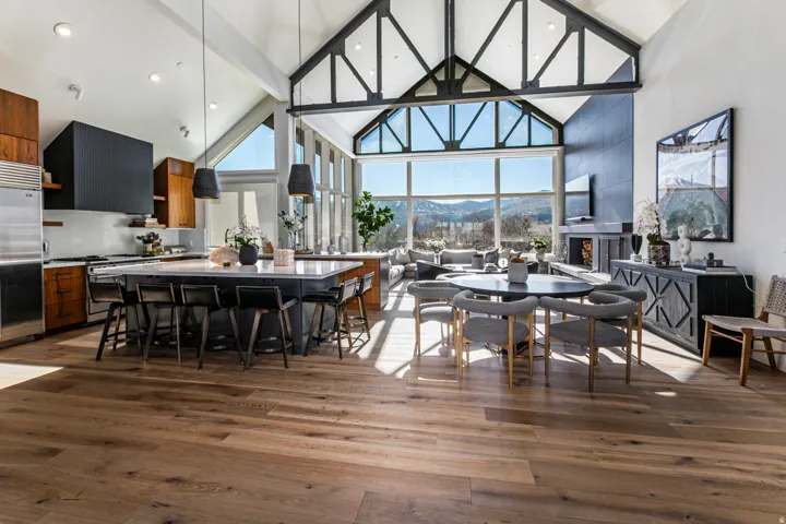 Dining space featuring high vaulted ceiling, dark wood finished floors, healthy amount of natural light, and beam ceiling