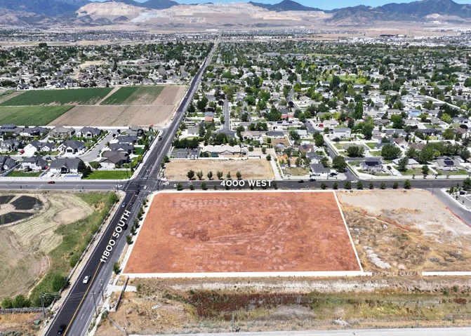 Aerial perspective of suburban area featuring a mountain backdrop and property boundaries highlighted