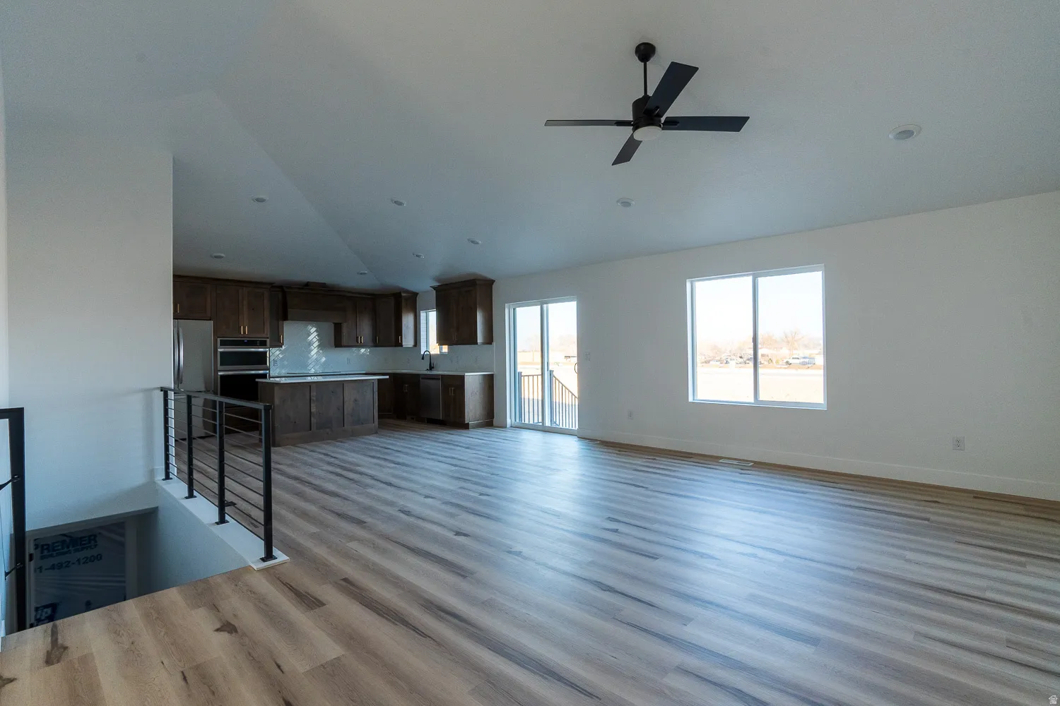 Unfurnished living room featuring lofted ceiling, light wood finished floors, and ceiling fan