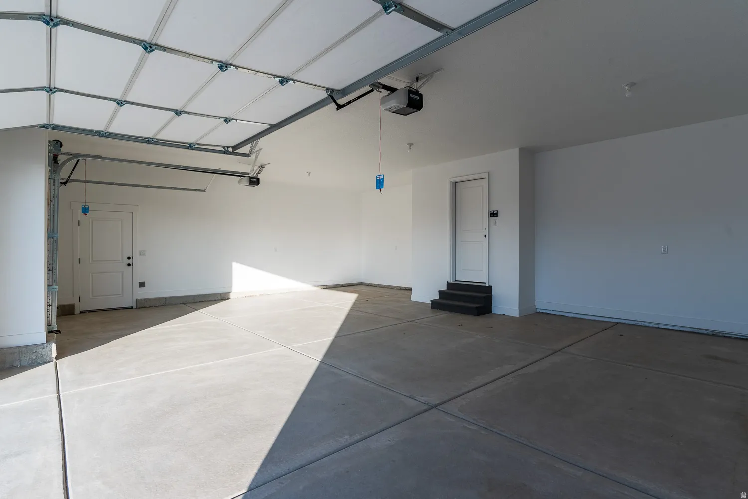 Garage with baseboards and a garage door opener