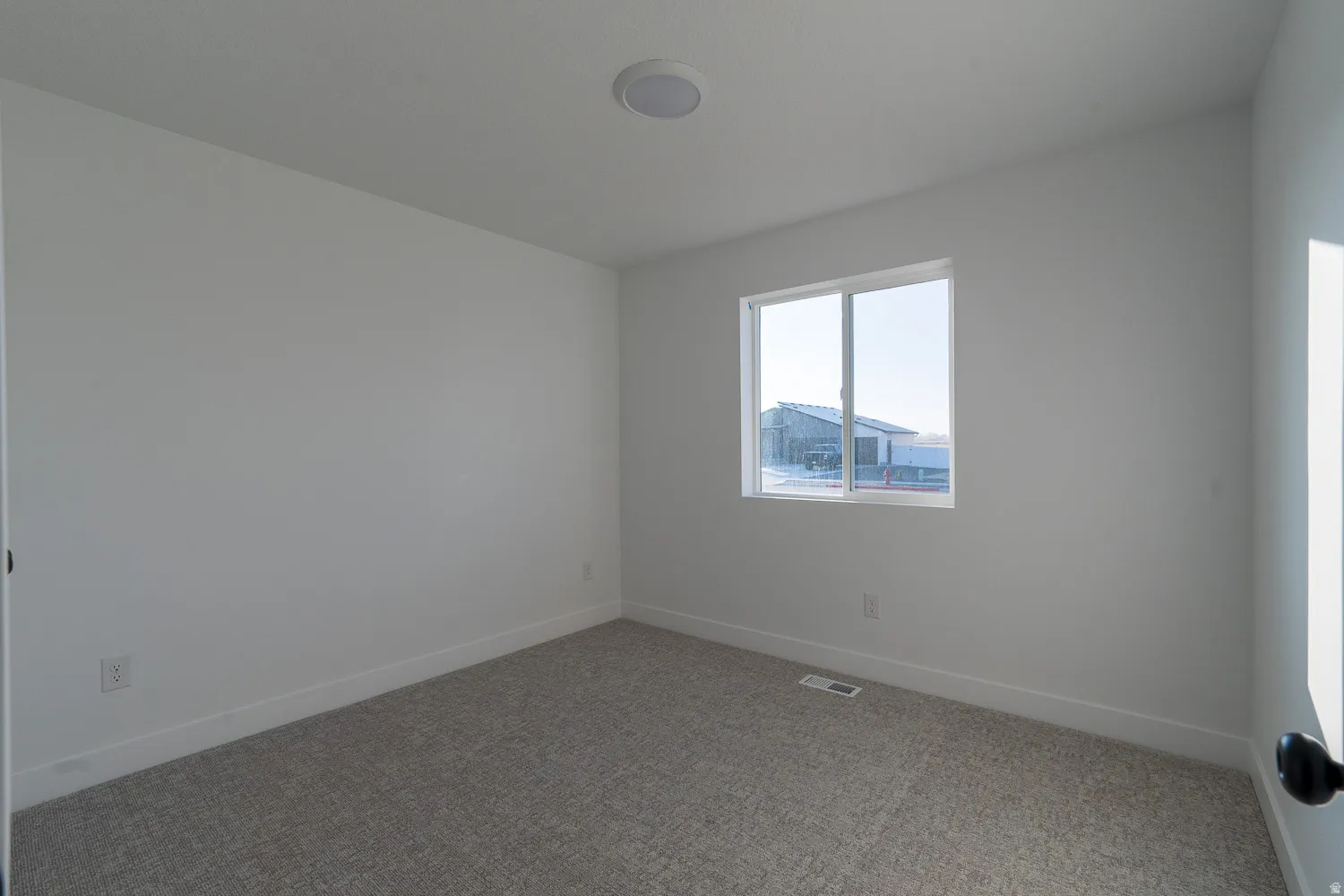Carpeted empty room with baseboards