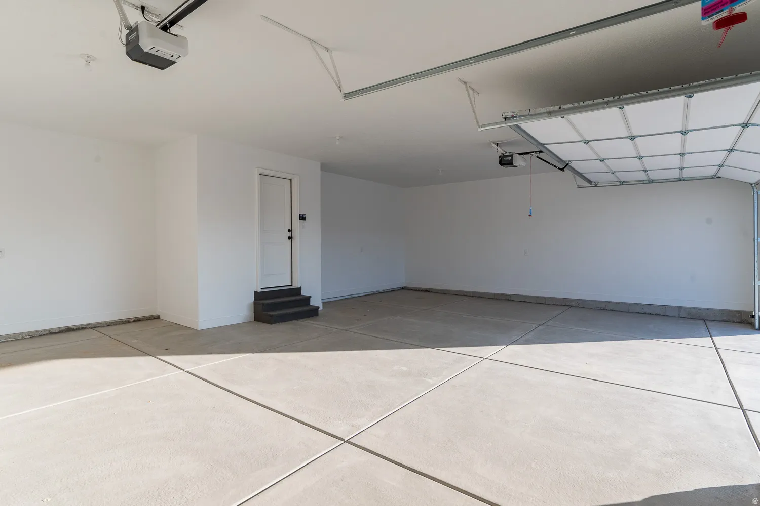 Garage featuring a garage door opener and baseboards