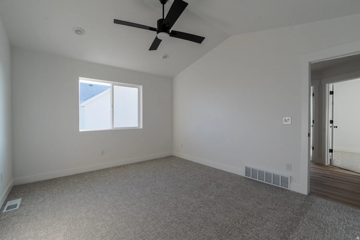 Unfurnished room featuring vaulted ceiling, carpet floors, and ceiling fan