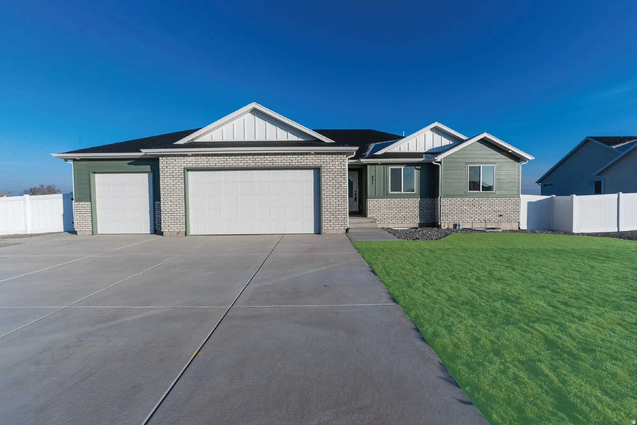 View of front of home with brick siding, board and batten siding, an attached garage, and concrete driveway