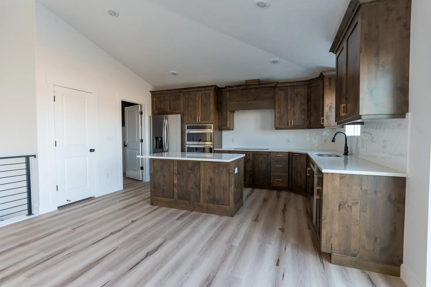 Kitchen featuring dark brown cabinetry, a kitchen island, appliances with stainless steel finishes, tasteful backsplash, and light wood-style floors