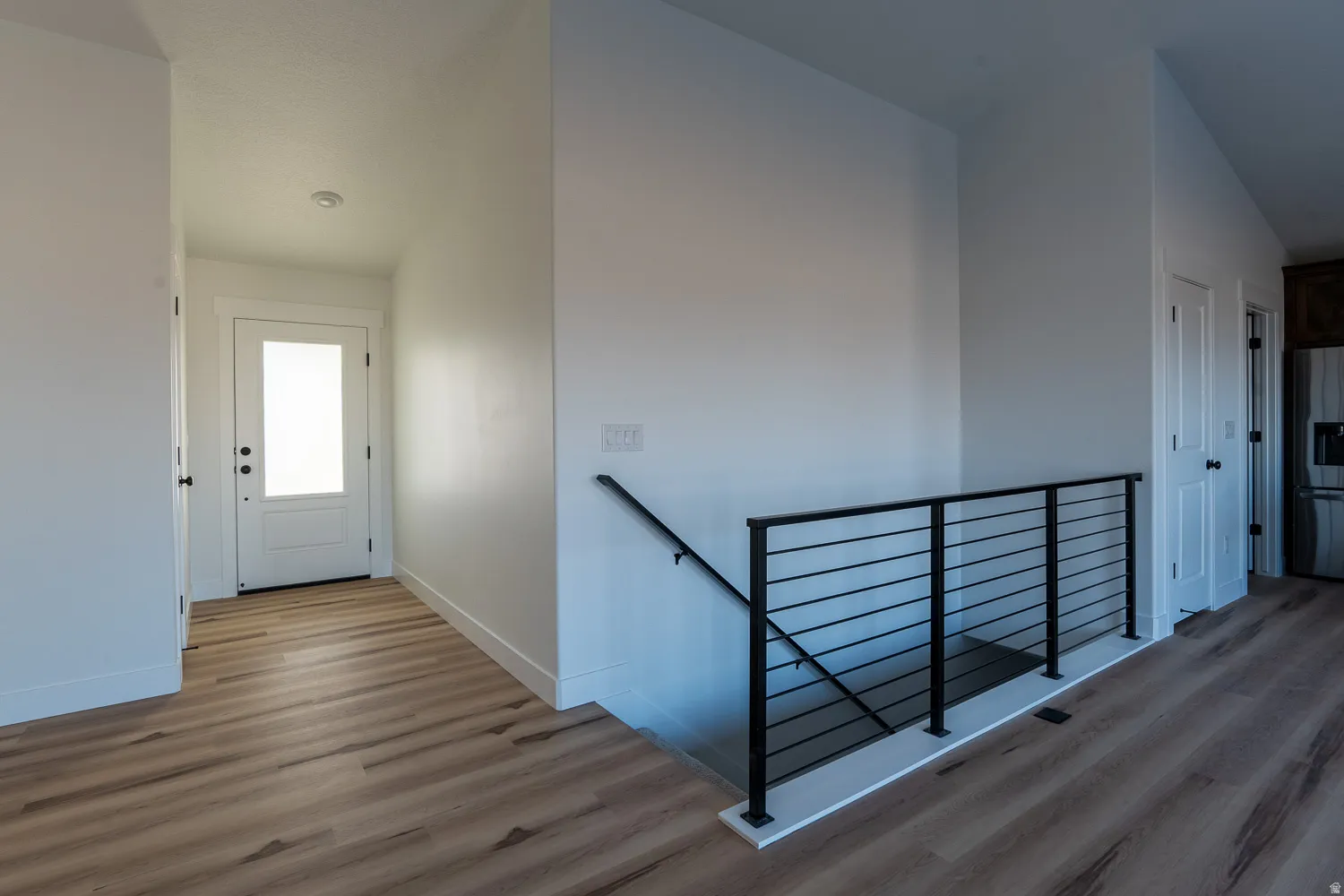 Corridor featuring an upstairs landing and light wood-style flooring