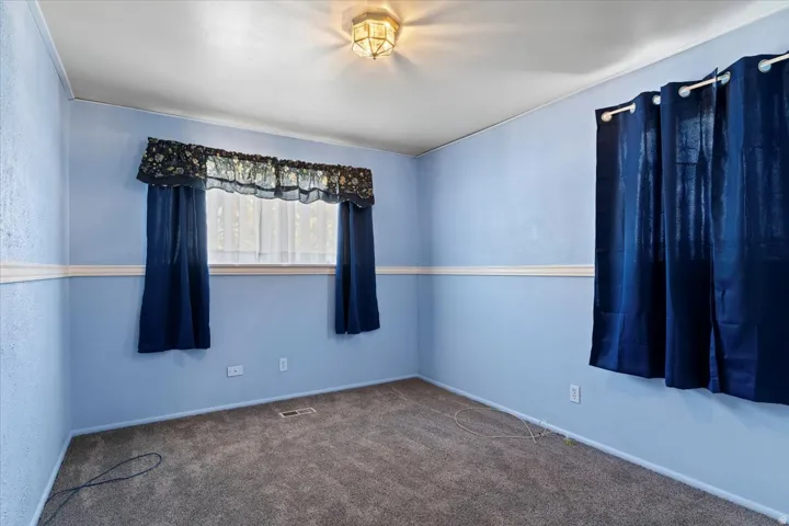 Spare room featuring carpet floors and baseboards