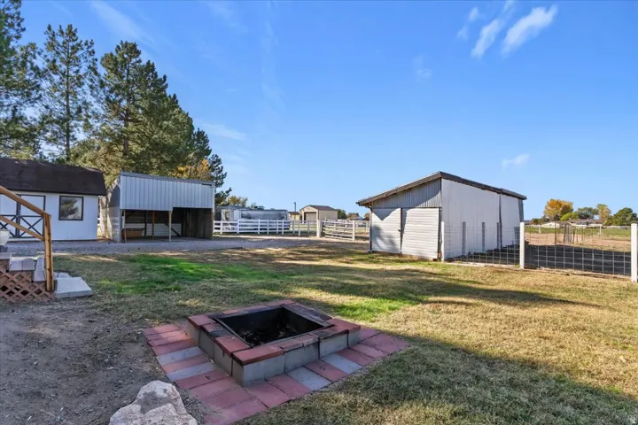 View of yard featuring an outbuilding, an outdoor structure, and an outdoor fire pit