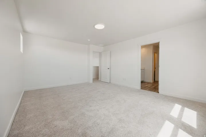 Neutral wall finishes, recessed lighting, and soft carpet flooring