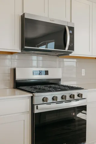 Stainless steel gas range with coordinating microwave above