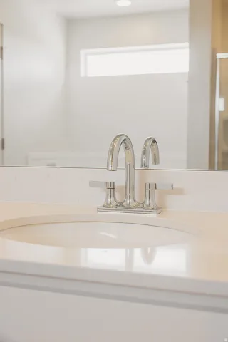 Chrome faucet fixtures, integrated countertop sink, light-toned countertop, recessed lighting, and a horizontal window