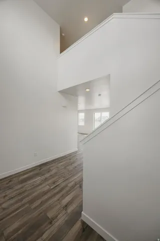 High ceilings with recessed lighting, wood-finish flooring, and crisp white walls