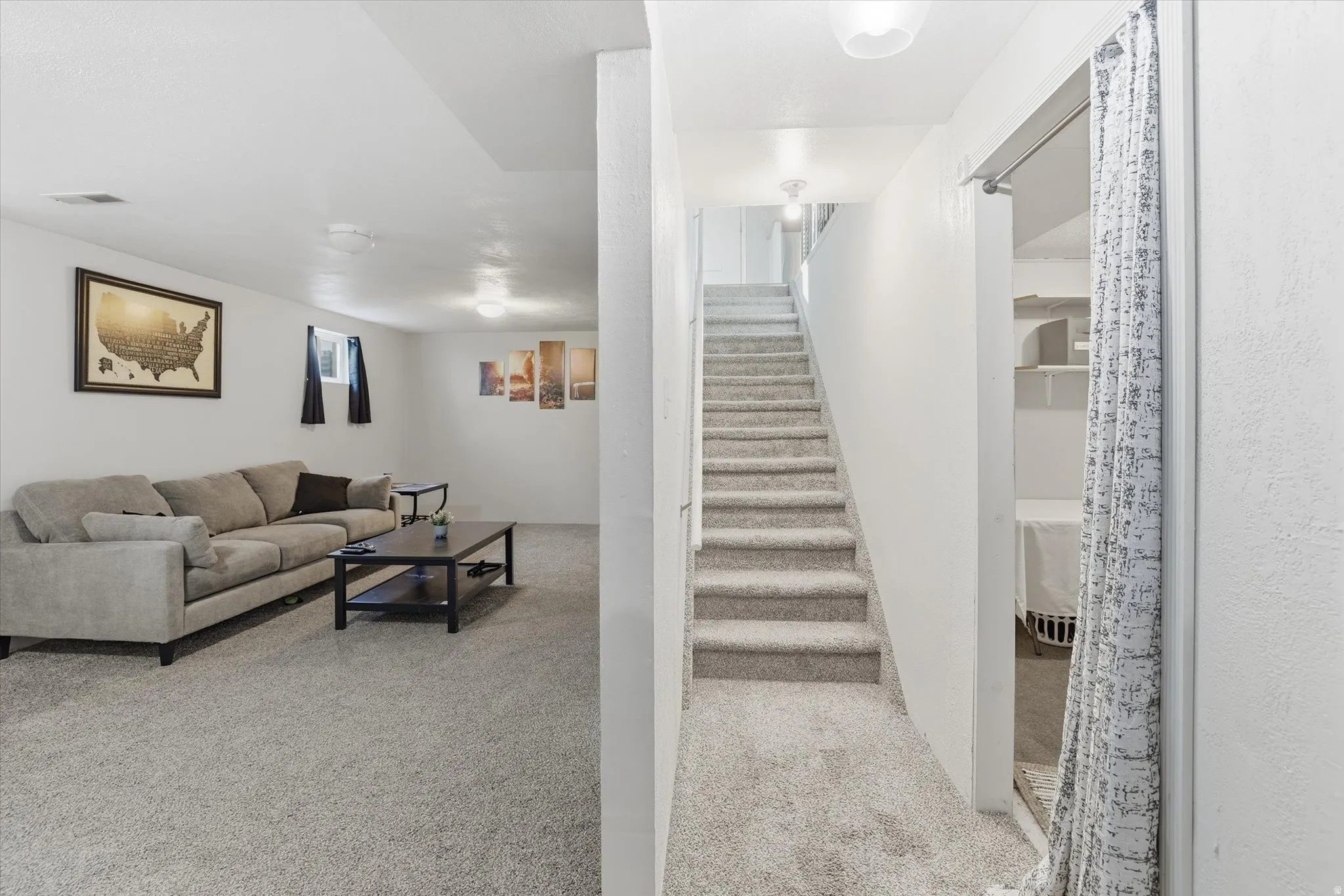 Living room featuring stairway and light colored carpet