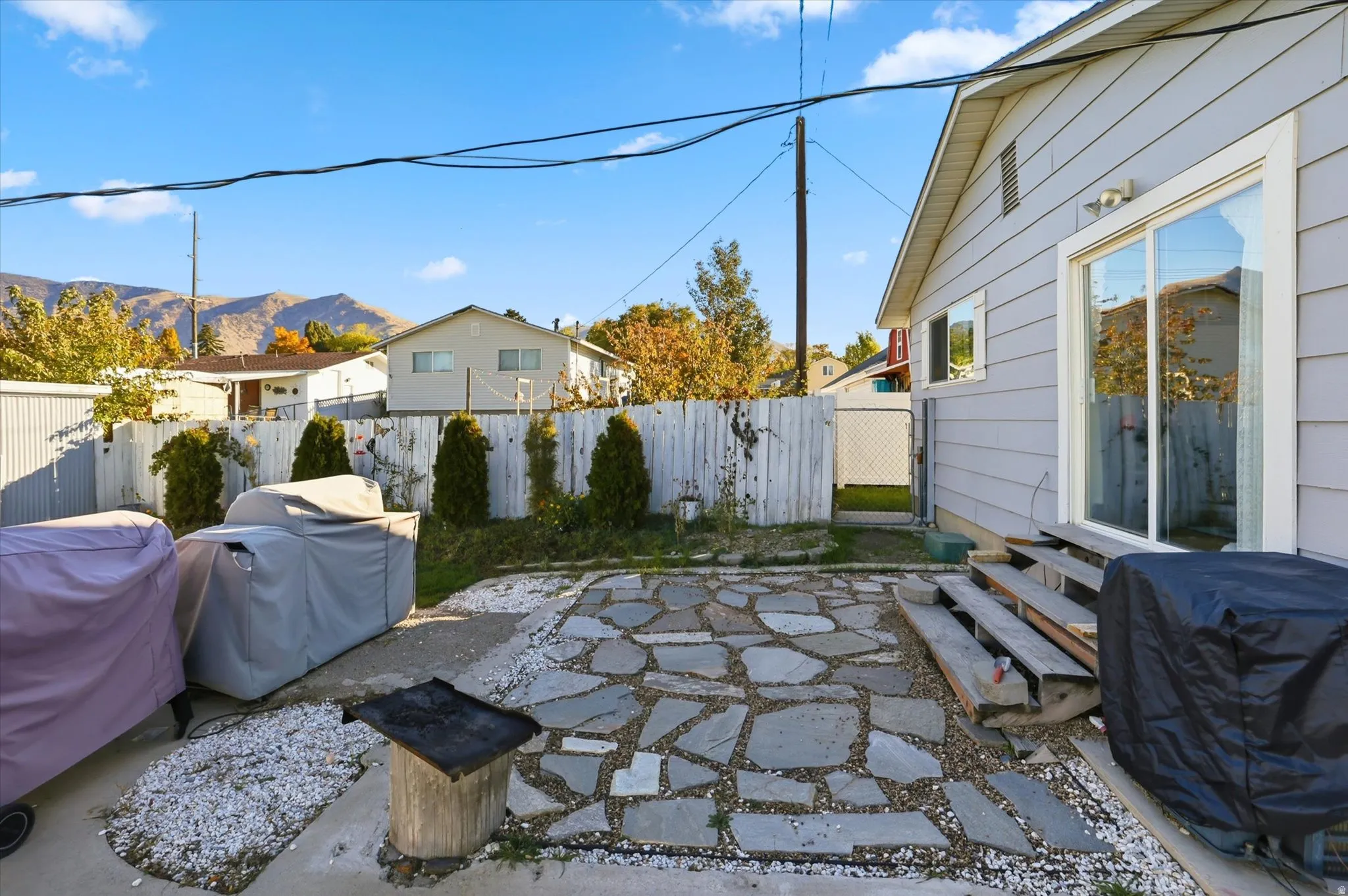 Fenced backyard with a patio and area for grilling