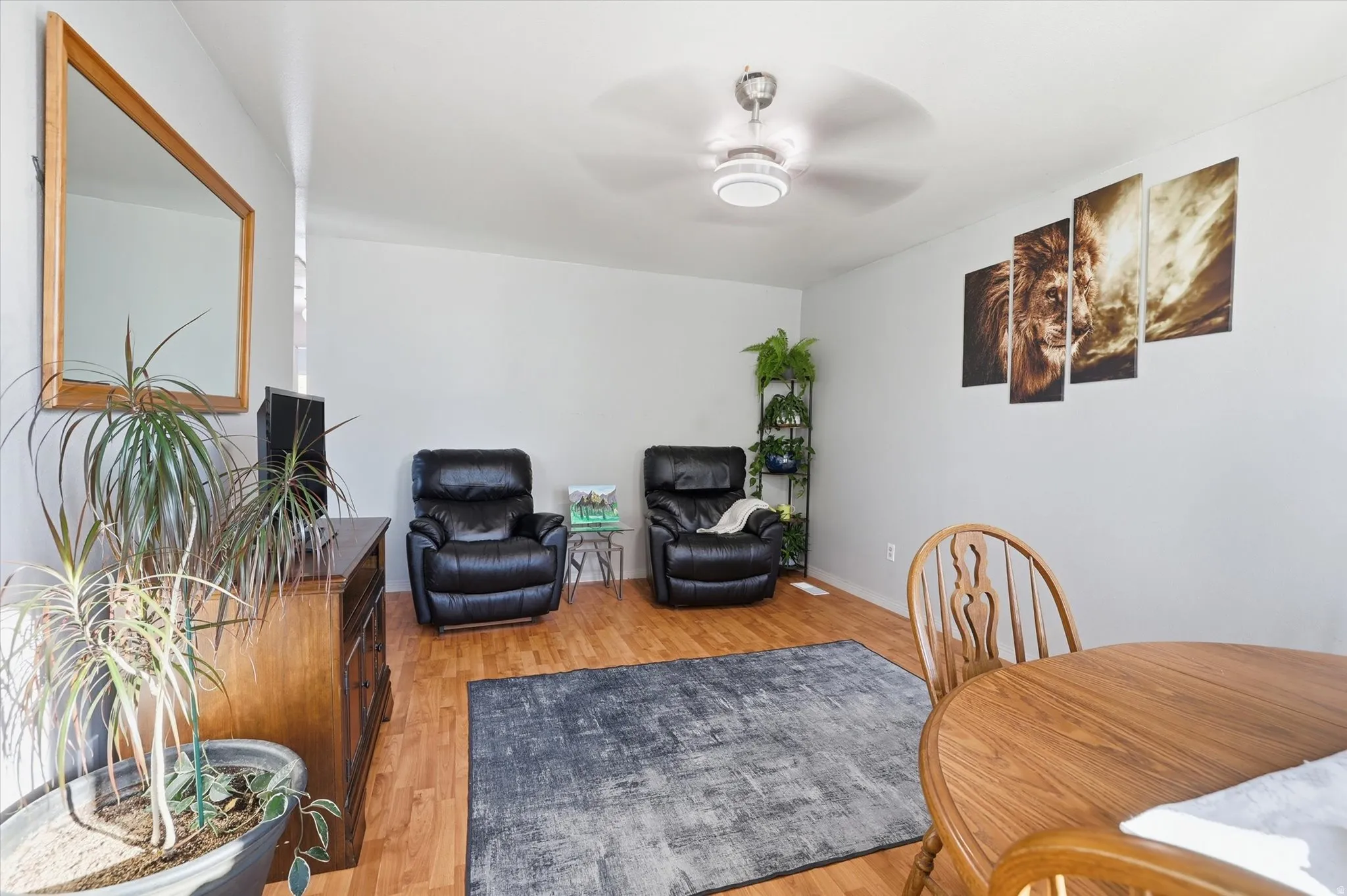 Sitting room with light wood-style flooring and a ceiling fan