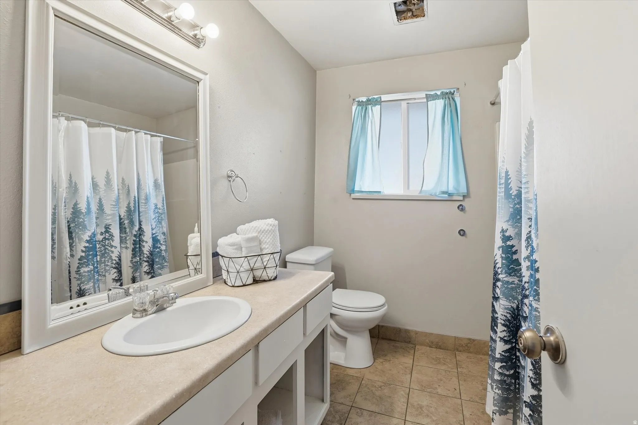 Full bathroom featuring vanity, a shower with shower curtain, and light tile patterned floors