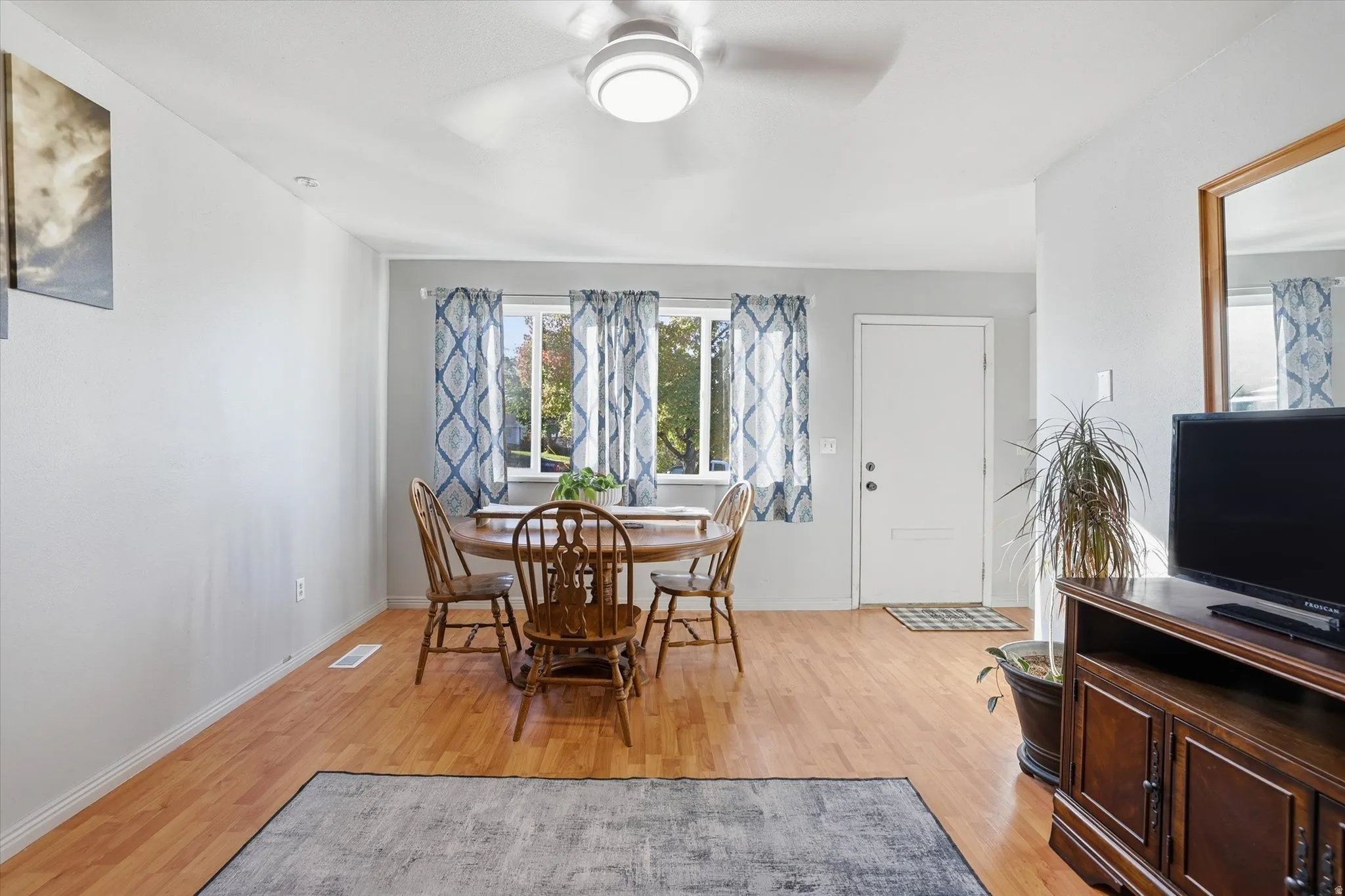 Dining space with light wood finished floors and a ceiling fan