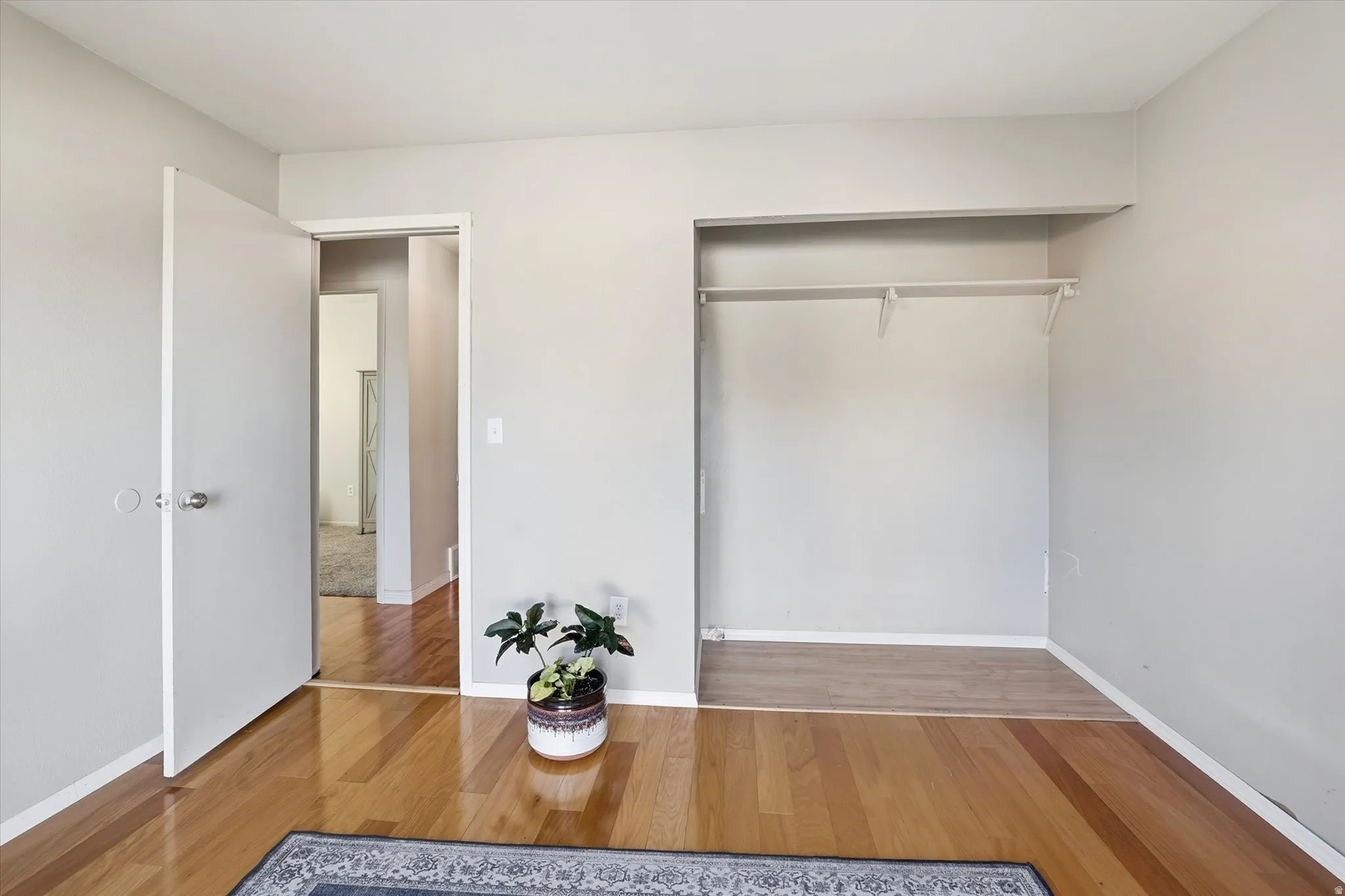 Unfurnished bedroom with wood finished floors and a closet