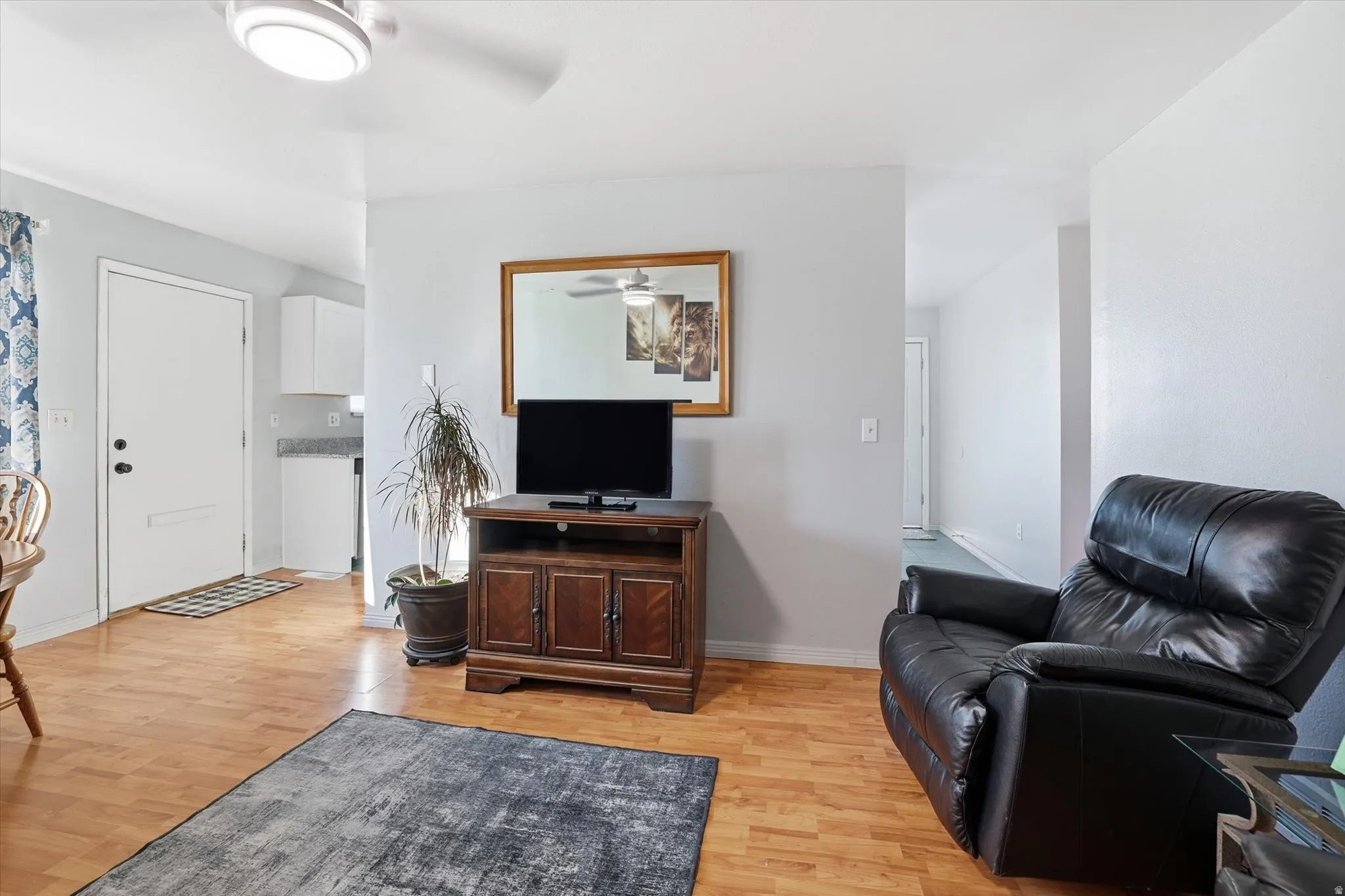 Living area with light wood-style floors and ceiling fan