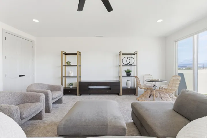 Carpeted living area with recessed lighting and ceiling fan
