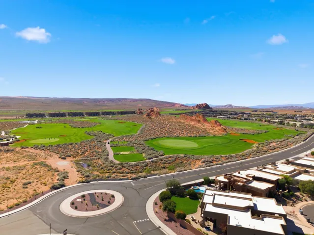 Drone / aerial view of a mountainous background and a golf course