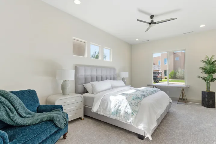 Carpeted bedroom featuring ceiling fan and recessed lighting