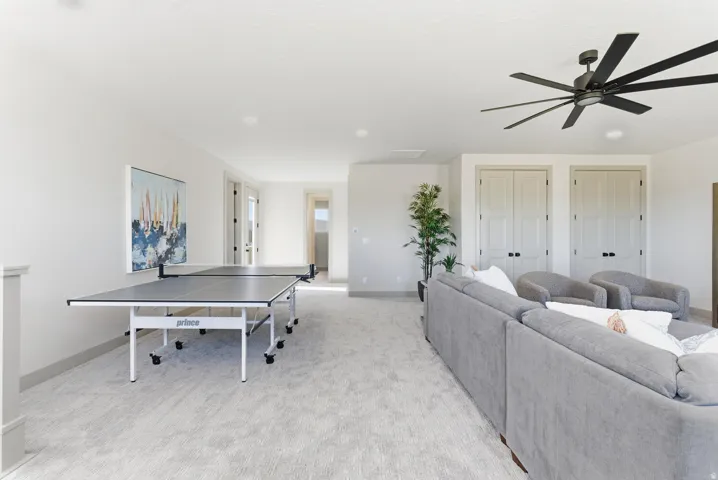 Recreation room featuring light carpet and a ceiling fan