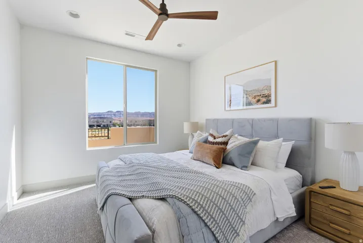 Carpeted bedroom with a ceiling fan and recessed lighting