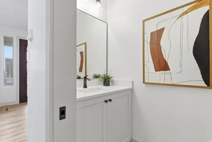 Half bath with vanity and light wood finished floors
