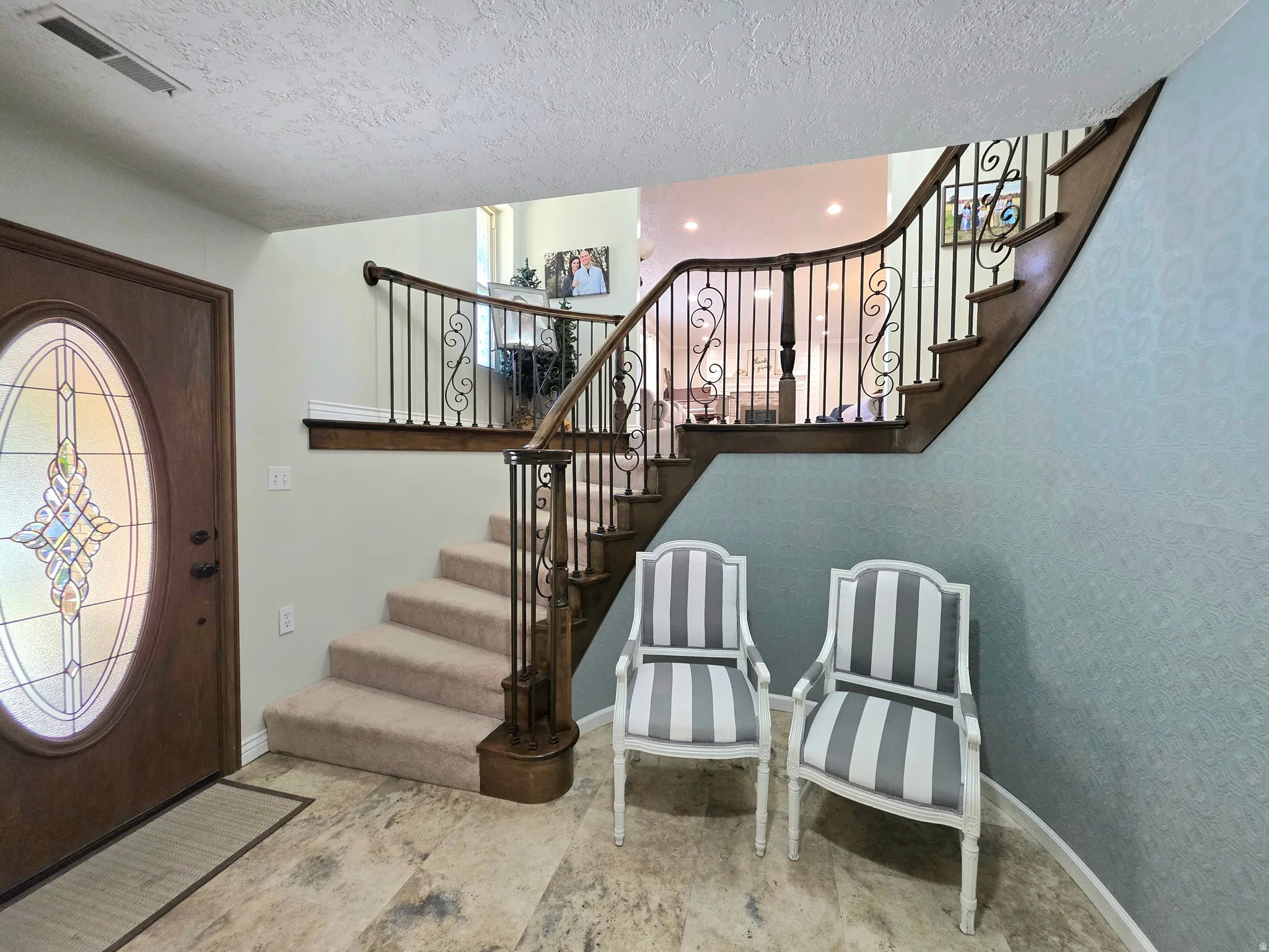Foyer with a textured ceiling and stairs