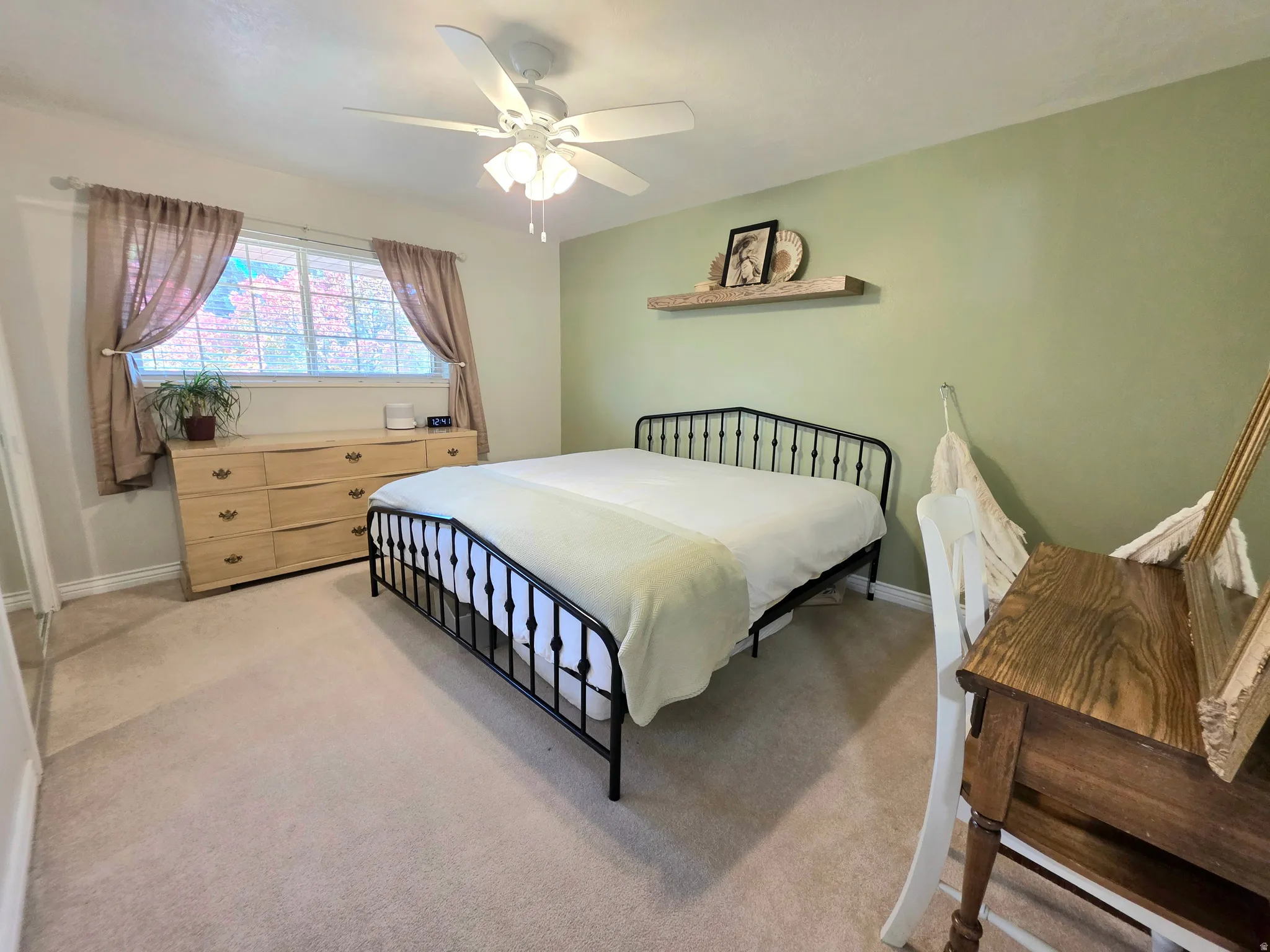Bedroom with light colored carpet and a ceiling fan