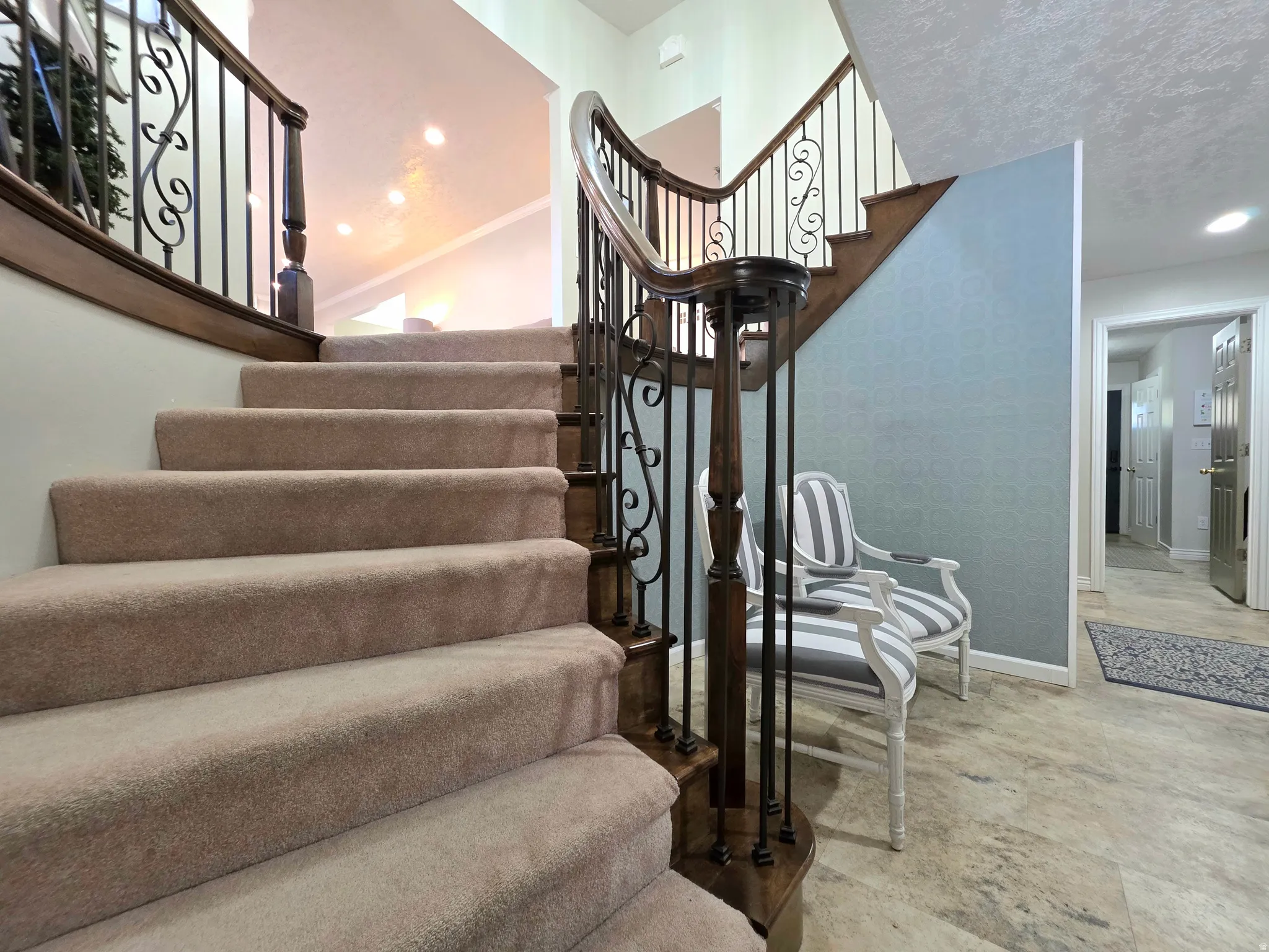Stairs featuring wallpapered walls, recessed lighting, and a textured ceiling