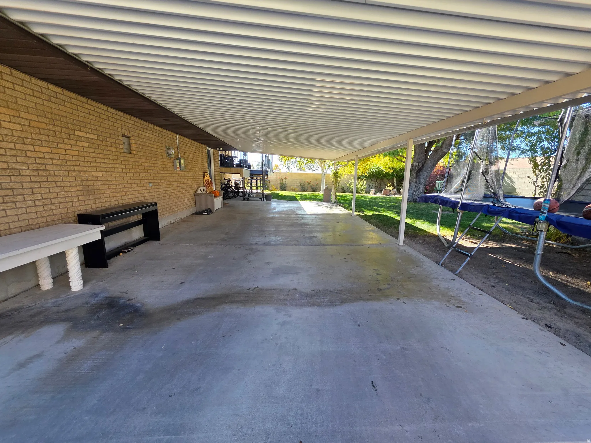 View of patio / terrace featuring a trampoline and an attached carport