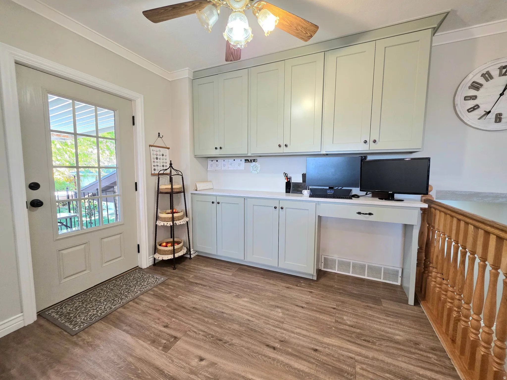 Office area featuring crown molding, dark wood-style flooring, built in study area, and ceiling fan