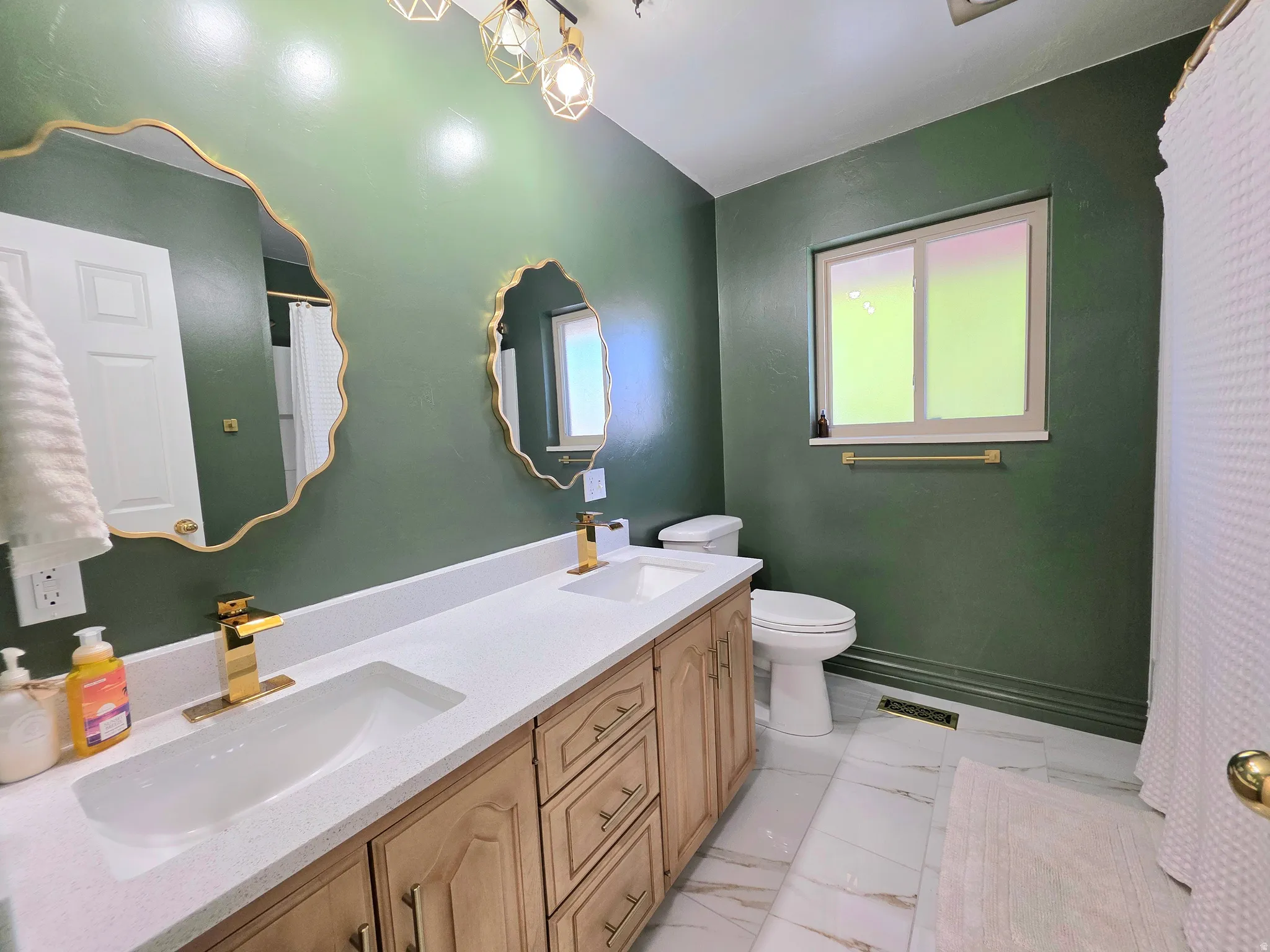 Full bath with a shower with curtain, double vanity, and light marble finish flooring