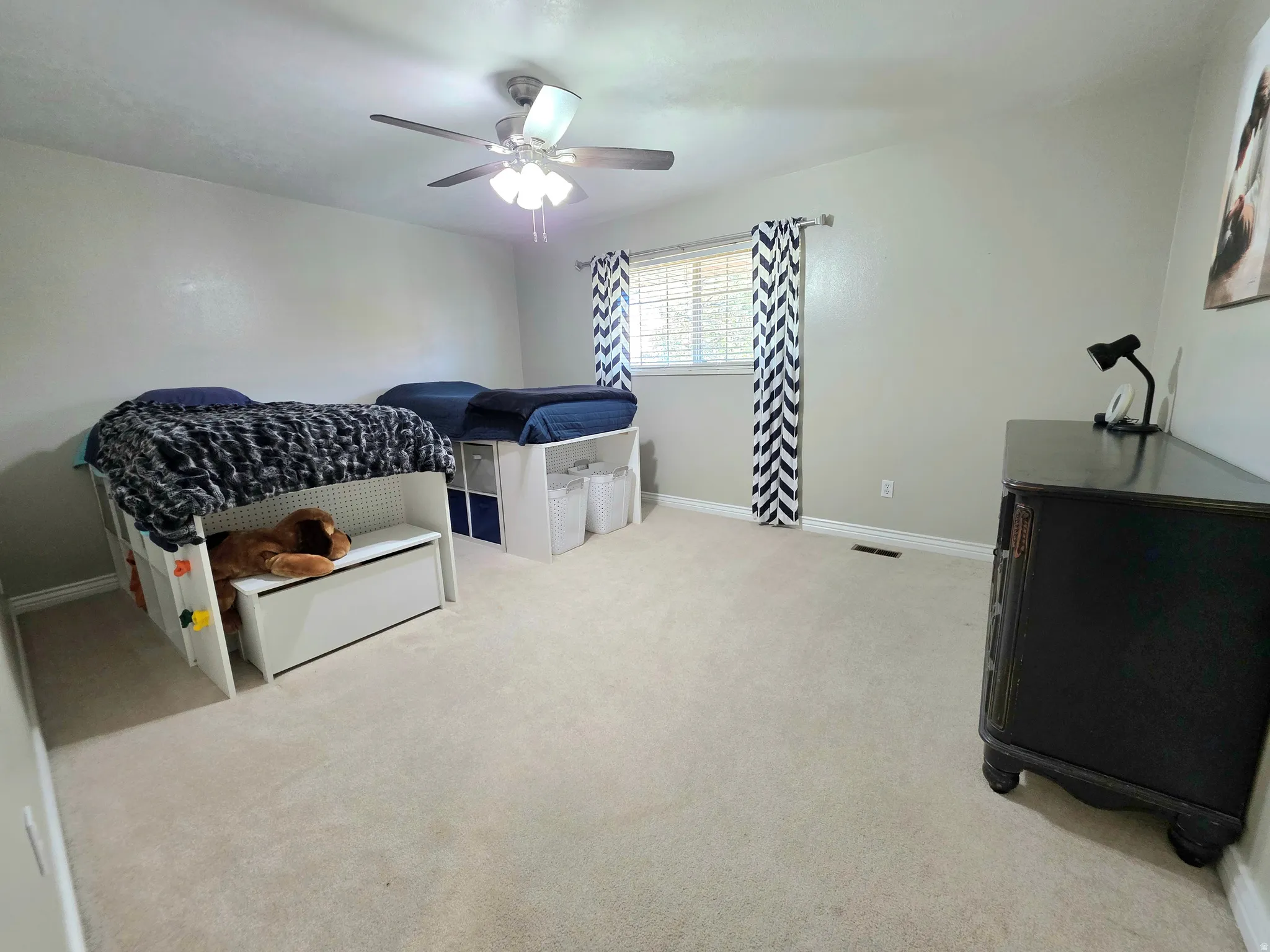 Bedroom with light carpet and ceiling fan