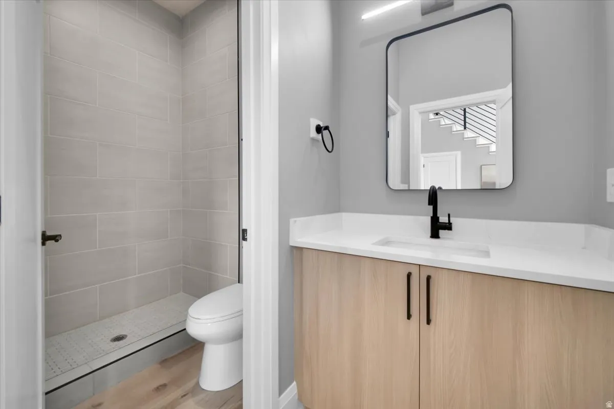 Full bathroom with vanity, light wood-style floors, and a stall shower