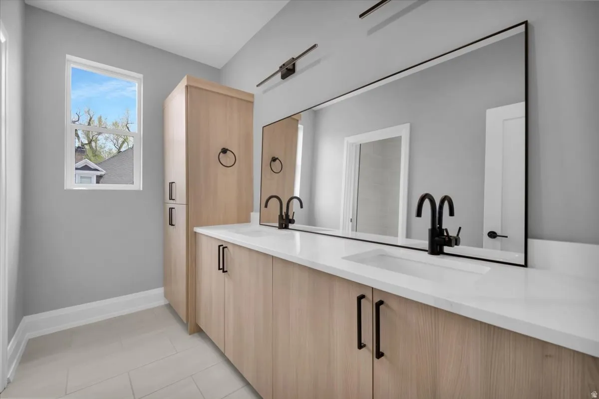 Bar area featuring light wood finish cabinetry, light stone countertops, light tile patterned flooring, and modern cabinets
