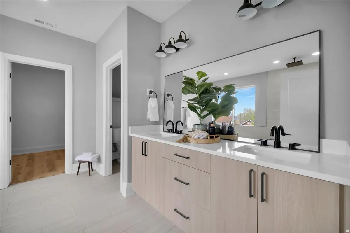 Full bathroom featuring double vanity and recessed lighting