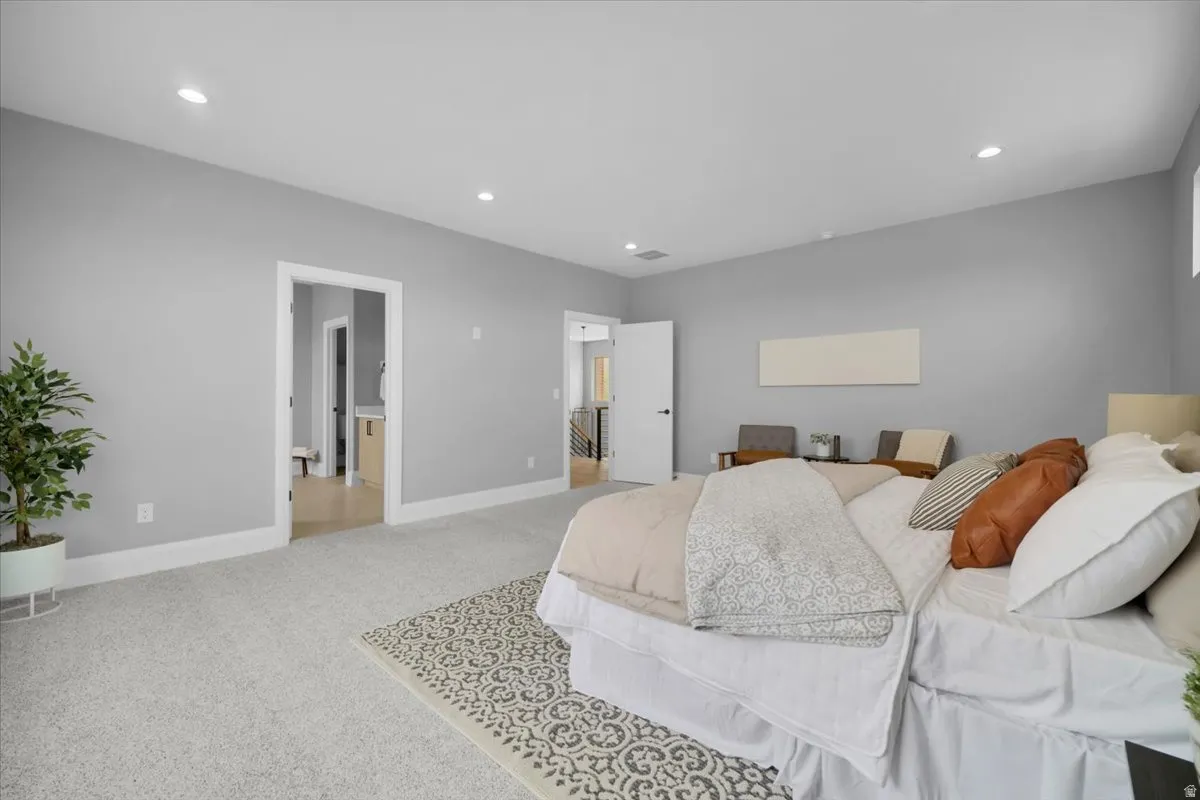 Bedroom with light colored carpet and recessed lighting