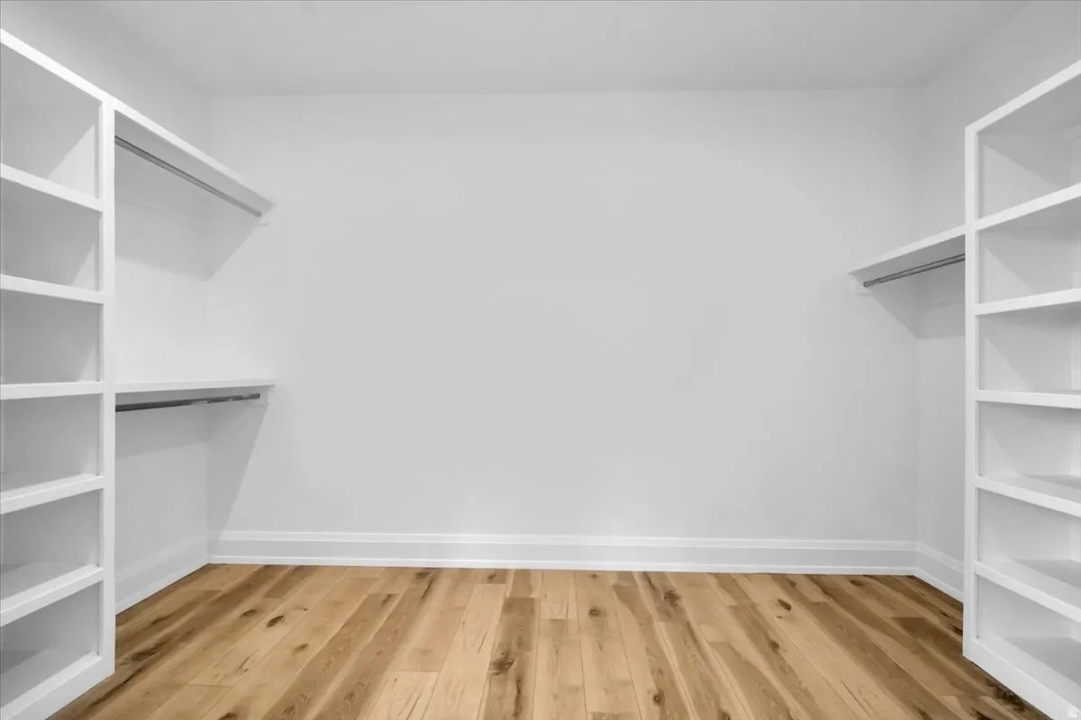 Walk in closet with light wood-type flooring