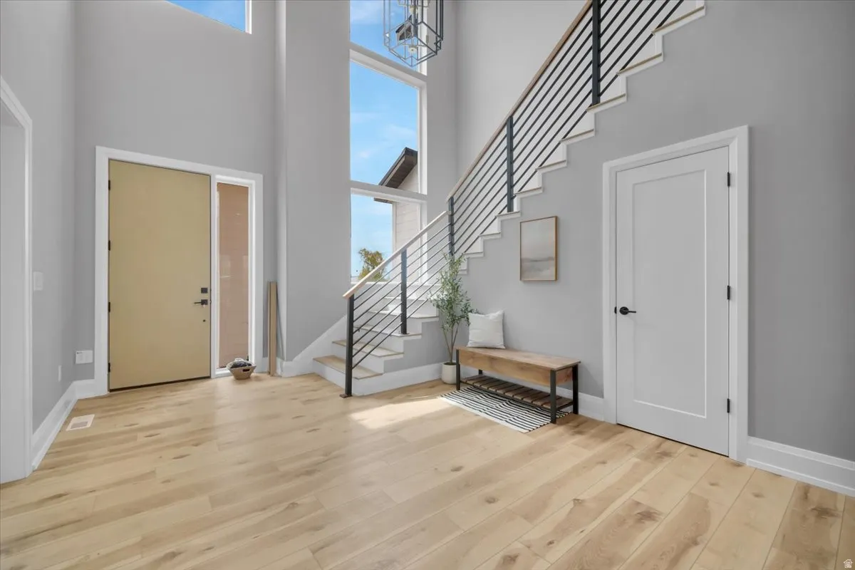 Entryway with a high ceiling and light wood-style flooring