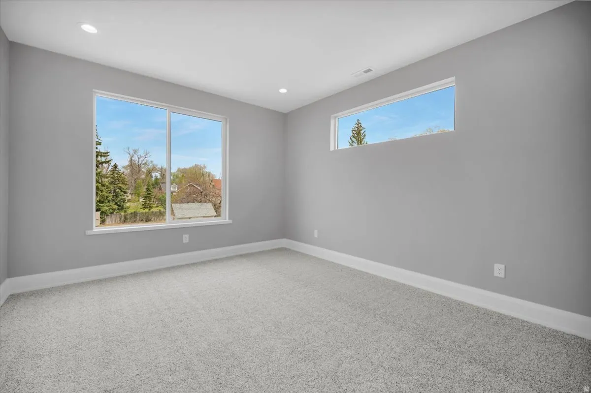 Empty room featuring light carpet and recessed lighting